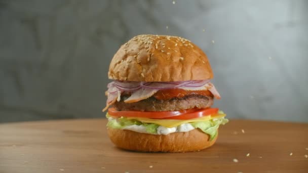 Semi di sesamo bianco che cadono in panino al rallentatore. Bun con sesamo per fare hamburger . — Video Stock