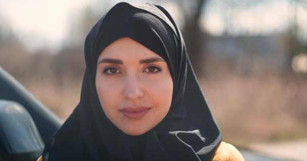 Närbild av en vacker muslimsk kvinna som tittar på kameran leende. Porträtt av professionell ung muslimsk kvinna tittar på kameran ler glad bär traditionell slöja — Stockvideo