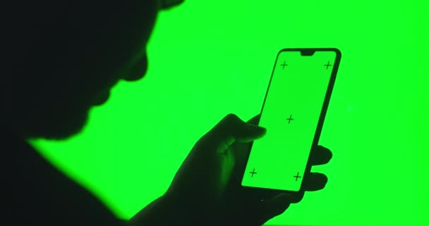 Elinde akıllı telefon olan bir adamın silueti yeşil arka planlı bir krom anahtarın üzerinde. Anahtar için yeşil ekran akıllı telefon. Tramvay krom anahtar akıllı telefon teknolojisi cep telefonu dokunuşu ekranı — Stok video