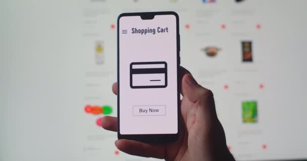 Konzept des Online-Shoppings auf einem Smartphone, das den Kauf-Knopf drückt. Online-Kauf und -Zahlung im Quarantäne- und Selbstisolierungsmodus. Lieferung und Fernzahlung. — Stockvideo