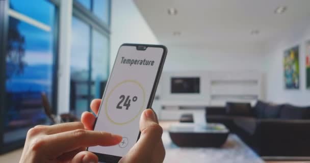 Domótica y control remoto. Cosas de Internet y tecnología inteligente moderna. Joven Hombre Guapo Da Mando a una Aplicación de Hogar Inteligente en Su Smartphone. Uso de la aplicación inteligente para el hogar en el dispositivo digital — Vídeos de Stock