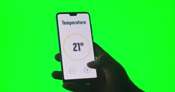 Die Hand steuert die Smart-Home-App mit einem Smartphone auf grünem Chromakey-Hintergrund — Stockvideo