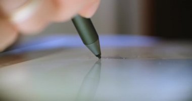 Dijital kalem ve tabletle çizim yapan adam. Serbest çalışan bir dijital sanatçı veya tasarımcı, çizim ve resim yaparken çizim tableti kullanıyor..