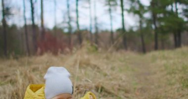 Yavaş Çekimde Lens Fişeği: Sonbahar parkında koşan mutlu erkek bebek. Küçük çocuk sonbahar yürüyüşünde oynuyor. Altın yapraklı sonbahar ormanı. Altın yapraklı sonbahar ormanı
