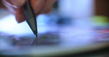 Dijital kalem ve tabletle çizim yapan adam. Serbest çalışan bir dijital sanatçı veya tasarımcı, çizim ve resim yaparken çizim tableti kullanıyor..