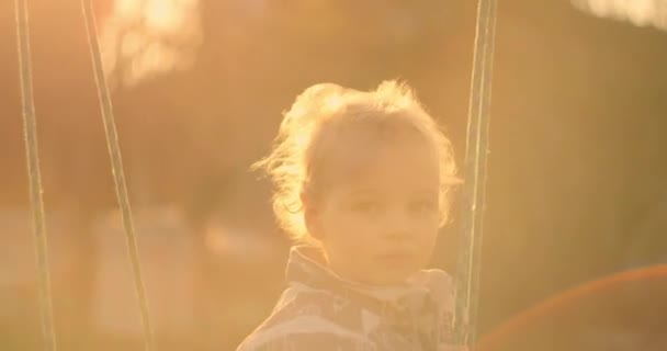 Zpomalený záběr roztomilého chlapce, jak si užívá svůj čas na houpačce. Zpomalený záběr roztomilého chlapce, jak si užívá svůj čas na houpačce. — Stock video