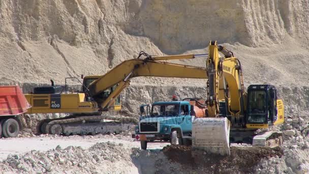 Excavadora vierte tierra en el camión — Vídeo de stock