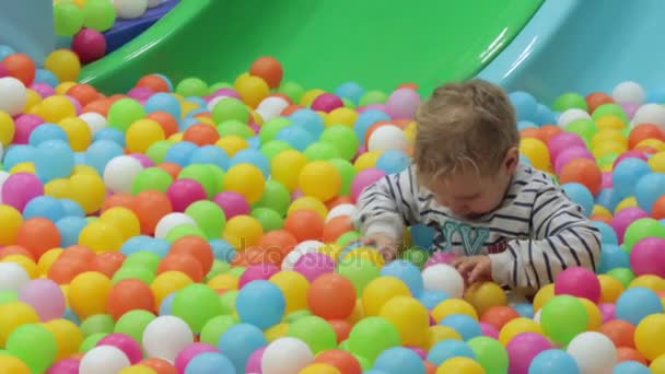 Niño jugando con bolas de colores — Vídeo de stock