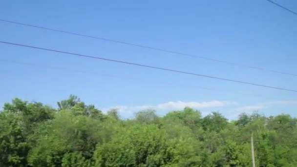 Tiro do trem, o céu, as árvores verdes, fios elétricos e suportes — Vídeo de Stock