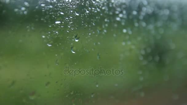 Esőcseppek a vonat ablakon. Az ablakon, elmosódott háttér. — Stock videók