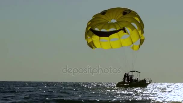 Paraquedas amarelos, o sorriso, a silhueta do barco — Vídeo de Stock