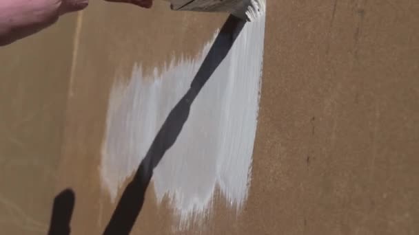 Pitture a mano per bambini con un pannello truciolare pennello primo piano — Video Stock