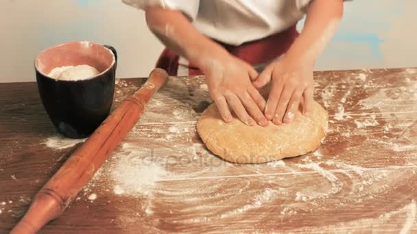 Girls hands knead the dough for biscuits on a table, closeup — Stock Video