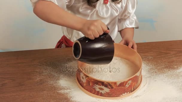女孩的厨师倒筛入面粉筛 — 图库视频影像