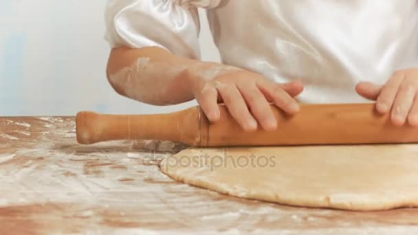 Las niñas manos con un rodillo amasar la masa en la mesa de cerca . — Vídeos de Stock