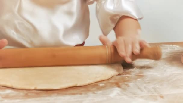 Flickor händer med en brödkavel Rulla degen på bordet närbild. — Stockvideo
