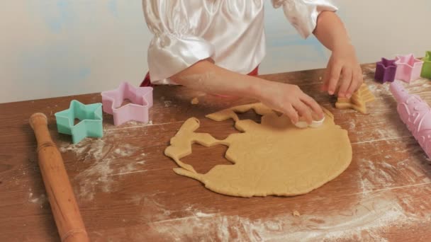 Les mains de l'enfant faisant des biscuits à partir de pâte crue en forme de coeur, fermer . — Video