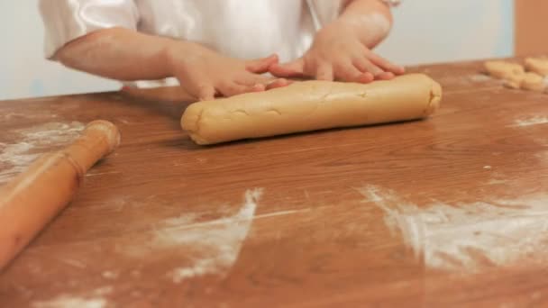 Girl chef rolls the dough by hand on a table, closeup. — Stock Video