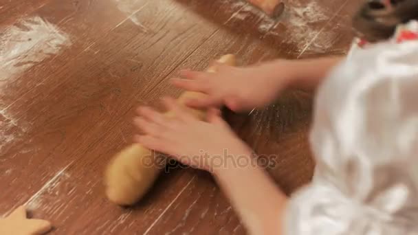 Ragazza chef rotola l'impasto a mano su un tavolo, vista dall'alto . — Video Stock