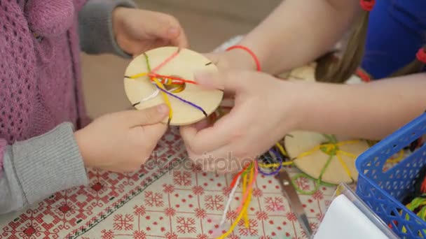 Дитяча рука плете браслет і коса кольорових ниток, крупним планом . — стокове відео