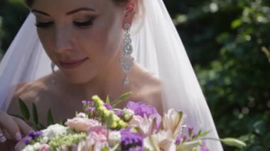 Bir buket çiçek tutan genç güzel gelin. Çekici bir kız portresi.