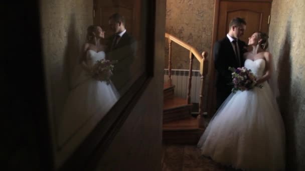 Recién casados reflejados en el espejo en el pasillo del hotel . — Vídeos de Stock