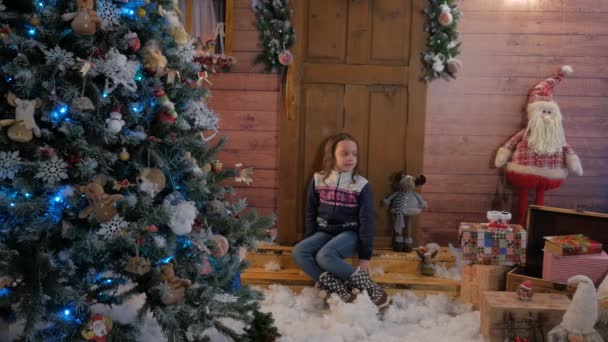 Une petite fille ouvre un cadeau de Noël . — Video