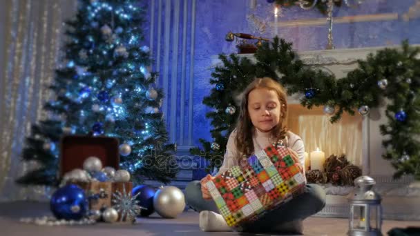 어린 소녀는 크리스마스 선물을 엽니다.. — 비디오