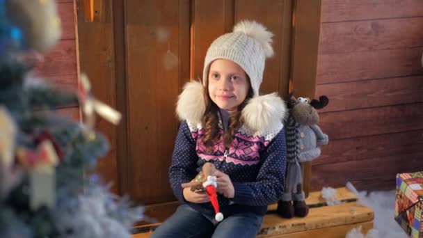 Niña cerca del árbol de Navidad esperando una sorpresa y sonrió — Vídeos de Stock