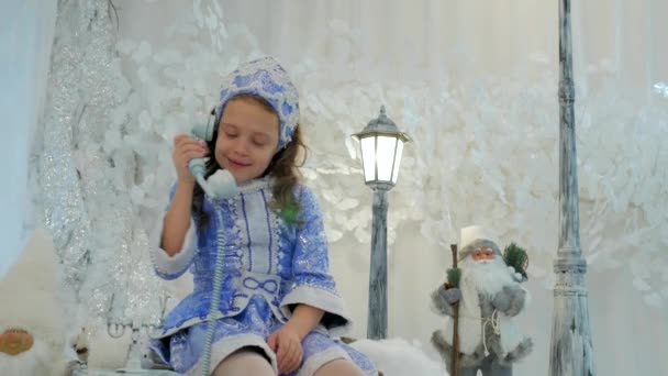 Fille en costume neige jeune fille parler sur vieux téléphone — Video