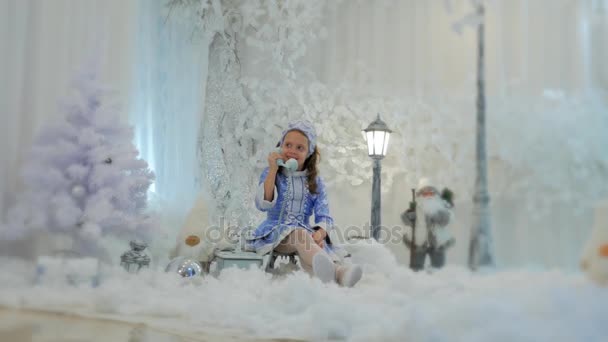 Fille en costume neige jeune fille parler sur vieux téléphone — Video