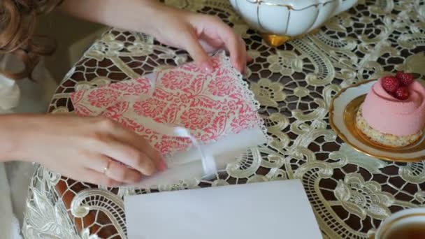 Крупный план, руки красивая девушка кладет романтическое письмо в конверт — стоковое видео
