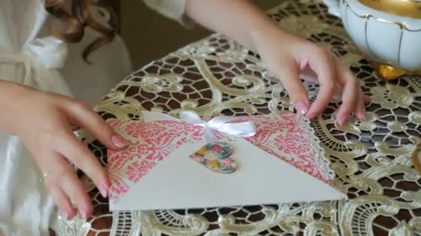 Primer plano, manos hermosa chica pone una carta romántica en un sobre — Vídeos de Stock