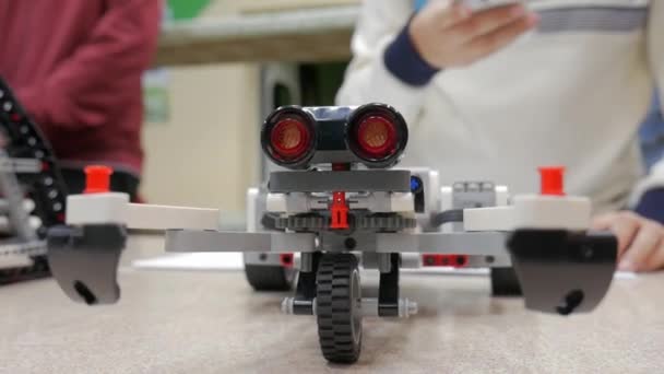 Closeup constructing modern robots first and programming their actions. — Stock Video