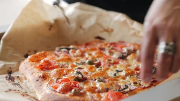 Una persona rebanando una pizza de pepperoni en rebanadas múltiples con un cortador de pizza. primer plano — Vídeo de stock