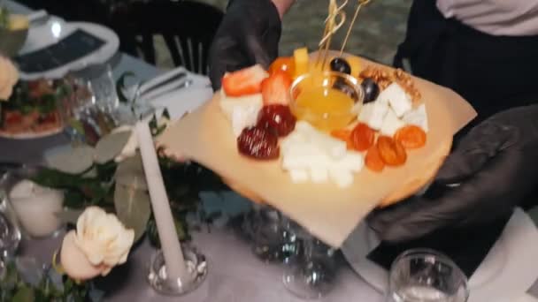 Le serveur met une assiette de nourriture sur la table dans le restaurant . — Video