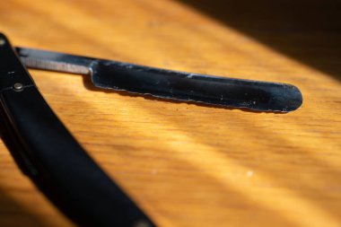 Ahşap arka planda eski bir jilet. Güneş parlıyor..