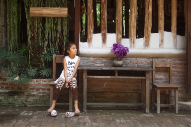 Asyalı kız vintage evinin önünde oturan.