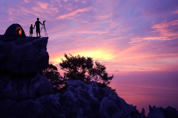 Family camping alone on the mountain with purple sky sunset. — Stock Photo, Image