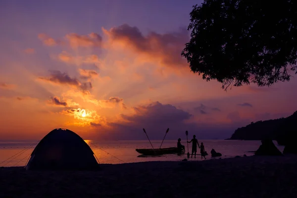 Família acampar e andar de caiaque na praia com o pôr do sol céu vermelho . — Fotografia de Stock