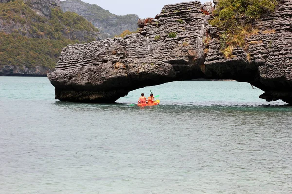 The couple paddle kayaking under the stone bridge. — Stock Photo, Image