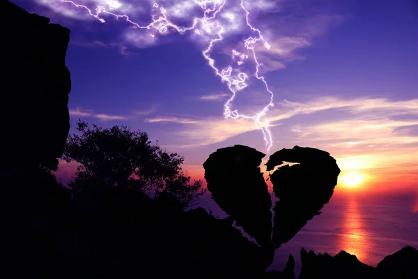 Sevgililer günü kavramı, kırık kalp şeklindeki taş bir dağ üzerinde aşağı yıldırım.