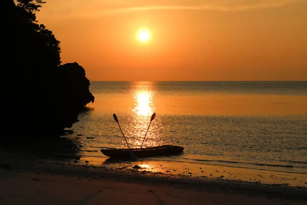 Kayak con cielo rojo puesta de sol en la playa . — Foto de Stock