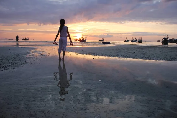 Asiatique fille tenant chaussures regarder coucher de soleil sur la plage . — Photo