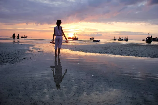 Asiatique fille tenant chaussures regarder coucher de soleil sur la plage . — Photo