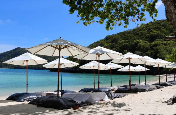 Sombrilla blanca y asiento de cojín de aire en la playa . — Foto de Stock