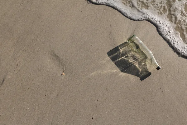 Glass bottle on the beach. — Stock Photo, Image