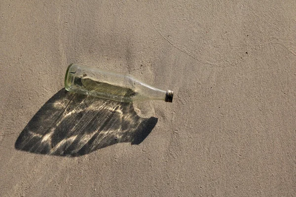 Glasflasche am Strand. — Stockfoto
