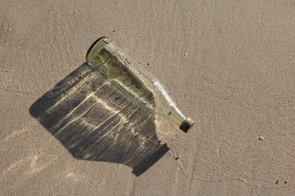 Glasflasche am Strand. — Stockfoto