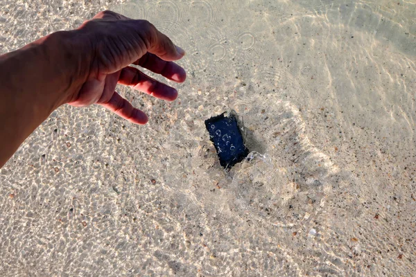 Handy fällt ins Meerwasser — Stockfoto